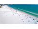 Aerial view of a beautiful, sandy beach with clear turquoise water and people enjoying the scenery at 1020 Sun N Sea Dr # 104B, Sarasota, FL 34242