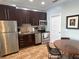 Modern kitchen featuring stainless steel appliances, tile flooring, and dark wood cabinets at 1020 Sun N Sea Dr # 104B, Sarasota, FL 34242