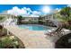 Inviting community pool surrounded by lounge chairs, tropical landscaping, and charming two-story buildings at 1020 Sun N Sea Dr # 104B, Sarasota, FL 34242