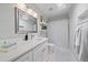 Bright bathroom with white cabinets, modern fixtures, vanity, and a shower with curtain at 1046 Greystone Ln, Sarasota, FL 34232