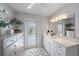 Bright bathroom with white cabinets, stone countertops, and door leading to outdoor pool at 1046 Greystone Ln, Sarasota, FL 34232