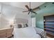 Bright bedroom features a ceiling fan, side table and a dark green accent wall with shelves at 1046 Greystone Ln, Sarasota, FL 34232