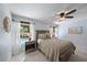Bright bedroom features a ceiling fan, wood furnishings and a window view of the pool at 1046 Greystone Ln, Sarasota, FL 34232
