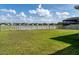 Spacious backyard with lush green grass, white fence, lake view and screened-in porch at 11702 Tetrafin Dr, Riverview, FL 33579