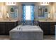 Elegant bathroom with dual sinks, a soaking tub under a window, and modern finishes at 11702 Tetrafin Dr, Riverview, FL 33579