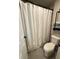 Bathroom featuring a shower with a curtain, toilet, and stacked towels for convenience at 11702 Tetrafin Dr, Riverview, FL 33579