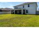 Exterior view of a two-story home featuring a screened-in lanai and spacious backyard at 11702 Tetrafin Dr, Riverview, FL 33579
