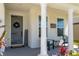 Inviting front porch with white columns, charming decor, and a welcoming entrance at 11702 Tetrafin Dr, Riverview, FL 33579