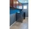 Well-lit laundry room showcasing modern side-by-side washer and dryer, cabinetry, and tile flooring at 11702 Tetrafin Dr, Riverview, FL 33579