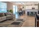 Inviting living room featuring wood-look tile floors, comfortable seating, and an open layout to kitchen and dining area at 11702 Tetrafin Dr, Riverview, FL 33579