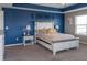 Bright bedroom featuring a decorative headboard, neutral carpet, and a blue accent wall at 11702 Tetrafin Dr, Riverview, FL 33579