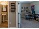View into office with a desk, shelving, carpet, and a glimpse of a small bathroom with a pedestal sink at 11702 Tetrafin Dr, Riverview, FL 33579