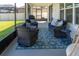 This screened patio offers seating, a patterned rug and a grill, perfect for relaxing and entertaining at 11702 Tetrafin Dr, Riverview, FL 33579