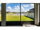 View from the screened porch overlooking a well-maintained lawn, lake and white fencing at 11702 Tetrafin Dr, Riverview, FL 33579