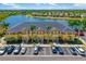 Aerial view of building near a lake, featuring a parking lot and beautiful trees at 12971 Tigers Eye Dr, Venice, FL 34292