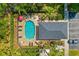 Aerial view of community pool featuring lounge chairs, palm trees, and a covered area at 12971 Tigers Eye Dr, Venice, FL 34292