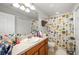 Bathroom with a single sink vanity and a shower with colorful geometric patterned shower curtain at 12971 Tigers Eye Dr, Venice, FL 34292