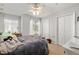 Cozy bedroom with two windows, a ceiling fan, two closets, and neutral colored carpet at 12971 Tigers Eye Dr, Venice, FL 34292