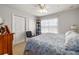 Bright bedroom featuring two closets, a ceiling fan, and a leafy blue and white comforter at 12971 Tigers Eye Dr, Venice, FL 34292