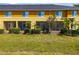 Back exterior of building featuring screen patios, green grass and minimal landscaping at 12971 Tigers Eye Dr, Venice, FL 34292