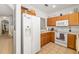 Bright kitchen featuring ample counter space, white appliances, and wood cabinets at 12971 Tigers Eye Dr, Venice, FL 34292