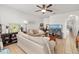 Comfortable living room with neutral tones, ceiling fan, and tile flooring throughout at 12971 Tigers Eye Dr, Venice, FL 34292
