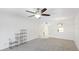Carpeted living room with ceiling fan, chandelier, and access to the hallway at 1330 Glen Oaks E Dr # 374D, Sarasota, FL 34232