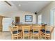 Wet bar with wood paneling and barstool seating overlooks the game room at 13615 4Th Ne Ave, Bradenton, FL 34212