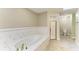 A pristine bathroom boasts a large tub, a glass shower, and tiled flooring at 13615 4Th Ne Ave, Bradenton, FL 34212