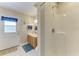 Bathroom with walk-in shower, vanity with cabinets, and a door leading outside at 13615 4Th Ne Ave, Bradenton, FL 34212