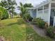 Landscaped yard featuring a meticulously maintained lawn, rock garden, and a variety of palms and flowering plants at 1654 Blakemore Ln, Sarasota, FL 34231