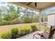 Inviting covered patio with rocking chair and views of lush backyard landscaping and open green space at 1800 Little Bird Ct, Sarasota, FL 34235
