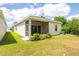 Back of home featuring a screened in lanai, manicured lawn, and green landscaping at 1800 Little Bird Ct, Sarasota, FL 34235