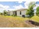 Back of the homes displaying a screened-in lanai, landscaped backyard, and exterior AC unit at 1800 Little Bird Ct, Sarasota, FL 34235