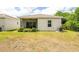 Exterior side view of the house showcasing a spacious backyard with greenery at 1800 Little Bird Ct, Sarasota, FL 34235