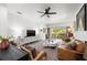 Bright living room with modern ceiling fan, white walls, and sliding doors to outdoor area at 1800 Little Bird Ct, Sarasota, FL 34235