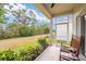 Relaxing screened patio with rocking chair and tranquil view of the lush backyard at 1800 Little Bird Ct, Sarasota, FL 34235