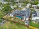 Aerial view of a home with a screened-in pool and solar panels on the roof at 1828 Mova St, Sarasota, FL 34231