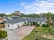Charming single-story home with lush landscaping, brick driveway, and solar panels at 1828 Mova St, Sarasota, FL 34231
