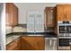 Kitchen area features a stainless sink, dishwasher, ovens, and wood cabinets with granite countertops at 1828 Mova St, Sarasota, FL 34231