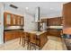 Kitchen featuring granite counters, wooden cabinets, stainless appliances, and an island with seating at 1828 Mova St, Sarasota, FL 34231