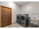 Laundry room equipped with modern washer and dryer, sink, and tiled flooring at 1828 Mova St, Sarasota, FL 34231