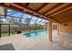 Screened-in pool area with brick pavers, landscaping, and outdoor seating at 1828 Mova St, Sarasota, FL 34231