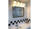 Bathroom featuring a bright vanity, black and white checkered tile, and decorative seashell accents at 205 46Th Avenue W Ter # 425, Bradenton, FL 34207
