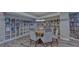 Cozy community library with shelves of books and a round table with chairs at 2301 Gulf Of Mexico Dr # 26N, Longboat Key, FL 34228