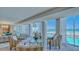 Comfortable lobby with chairs, tables, and floor to ceiling windows overlooking pool and beach at 2301 Gulf Of Mexico Dr # 26N, Longboat Key, FL 34228