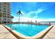 Expansive community pool surrounded by lounge chairs and views of the ocean at 2301 Gulf Of Mexico Dr # 26N, Longboat Key, FL 34228