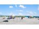 Beautiful beachfront scene with sunny skies, blue ocean, and many beachgoers enjoying the day at 2311 Sunnyside Pl, Sarasota, FL 34239