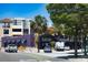 A view of McCurdy's Comedy Theatre with lush trees and landscaping with a variety of parked cars nearby at 2311 Sunnyside Pl, Sarasota, FL 34239