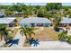 Charming single-story home with a brick walkway and mature palm trees in a sunny Florida neighborhood at 2311 Sunnyside Pl, Sarasota, FL 34239